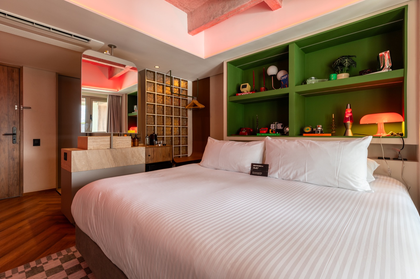 Habitación de BoH Hotel con biblioteca verde y luz rosada